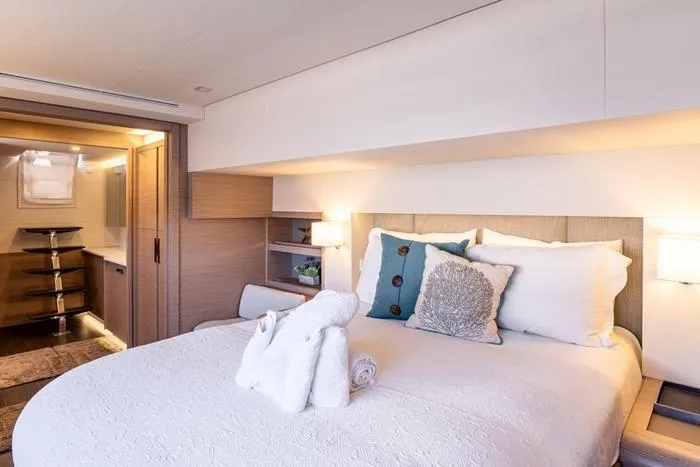 Port To Vino 2 Yacht Photos Pics Luxurious bedroom interior of 2023 Fountaine Pajot Samana 59 yacht with elegant decor.