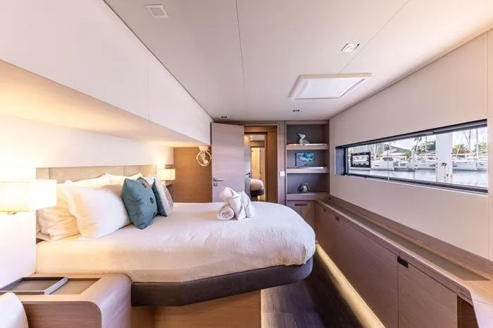 Port To Vino 2 Yacht Photos Pics Luxurious bedroom interior of 2023 Fountaine Pajot Samana 59 yacht with modern design.