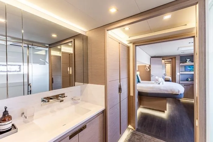 Port To Vino 2 Yacht Photos Pics Luxurious interior of 2023 Fountaine Pajot Samana 59 yacht, featuring modern bathroom and bedroom.