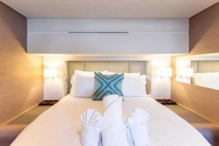 Port To Vino 2 Yacht Photos Pics Luxurious bedroom interior of 2023 Fountaine Pajot Samana 59 yacht with elegant decor.