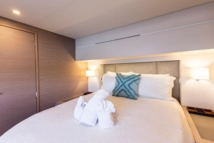 Port To Vino 2 Yacht Photos Pics Luxurious bedroom interior on 2023 Fountaine Pajot Samana 59 yacht with elegant bedding.