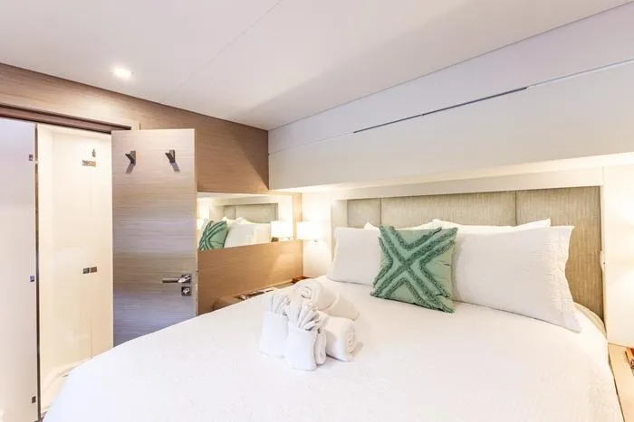 Port To Vino 2 Yacht Photos Pics Luxurious bedroom interior of 2023 Fountaine Pajot Samana 59 yacht with elegant decor.