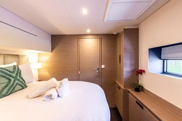 Port To Vino 2 Yacht Photos Pics Luxurious bedroom interior of 2023 Fountaine Pajot Samana 59 yacht with modern decor.