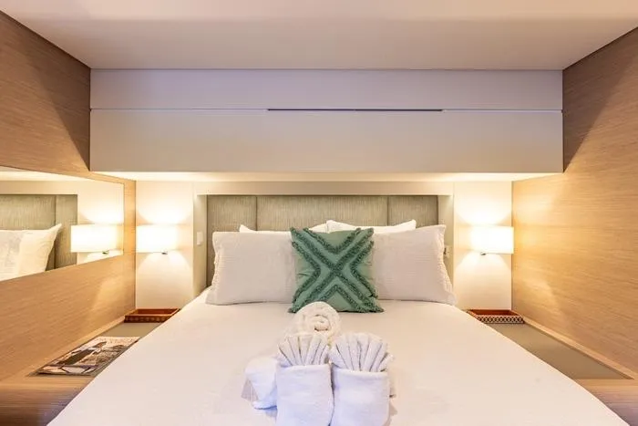 Port To Vino 2 Yacht Photos Pics Luxurious bedroom interior on 2023 Fountaine Pajot Samana 59 yacht, featuring elegant decor and plush bedding.