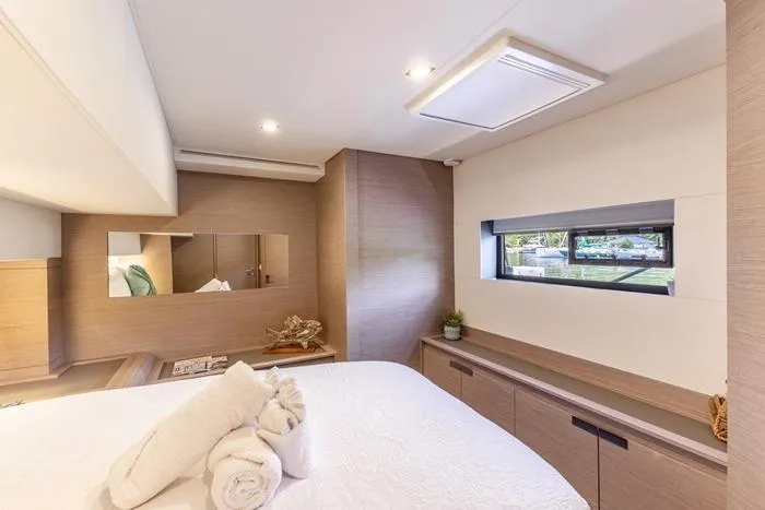 Port To Vino 2 Yacht Photos Pics Luxurious bedroom interior of 2023 Fountaine Pajot Samana 59 yacht, featuring modern design and natural light.