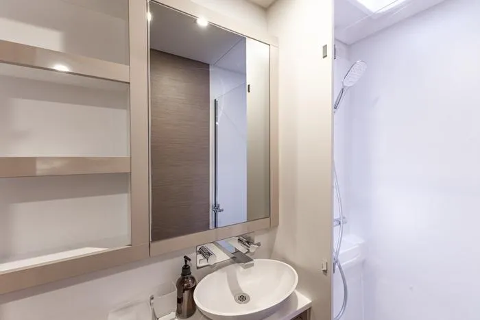 Port To Vino 2 Yacht Photos Pics Modern bathroom interior on 2023 Fountaine Pajot Samana 59 yacht, featuring sleek sink and mirror.