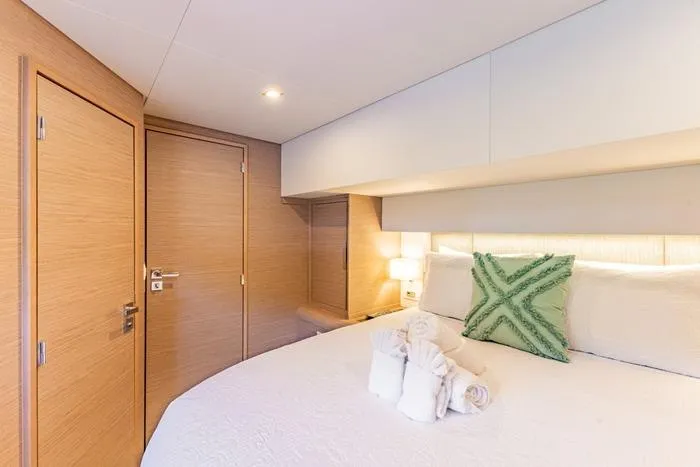 Port To Vino 2 Yacht Photos Pics Luxurious cabin interior of 2023 Fountaine Pajot Samana 59 yacht with elegant bedding.