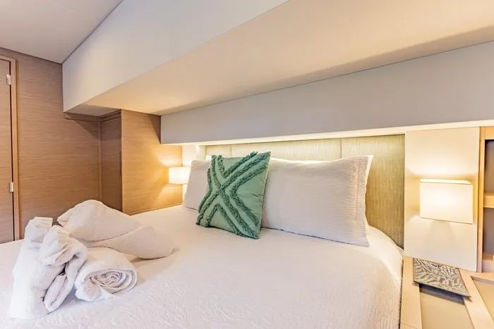 Port To Vino 2 Yacht Photos Pics Luxurious bedroom interior of 2023 Fountaine Pajot Samana 59 yacht with elegant bedding.