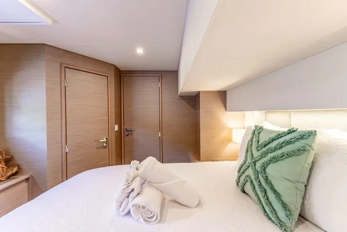 Port To Vino 2 Yacht Photos Pics Luxurious cabin interior of 2023 Fountaine Pajot Samana 59 yacht with elegant bedding.