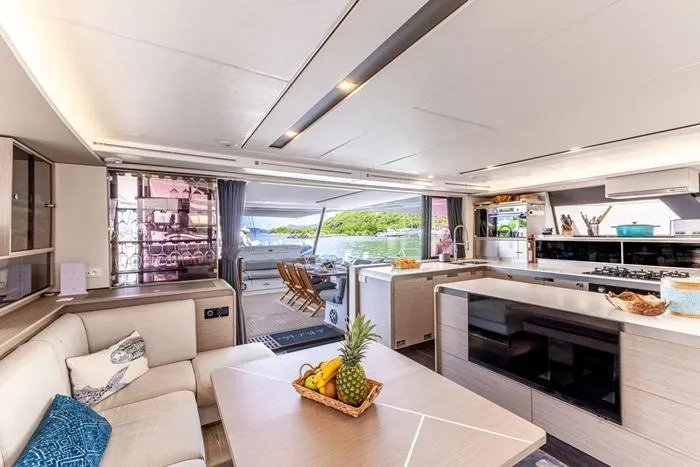 Port To Vino 2 Yacht Photos Pics Luxurious interior of 2023 Fountaine Pajot Samana 59 yacht with modern kitchen and dining area.