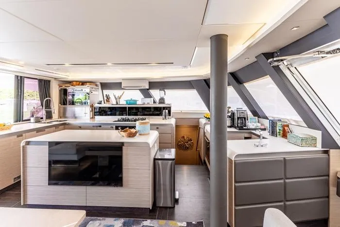 Port To Vino 2 Yacht Photos Pics Luxurious interior of 2023 Fountaine Pajot Samana 59 yacht with modern kitchen design.
