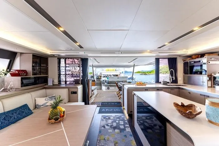 Port To Vino 2 Yacht Photos Pics Luxurious interior of 2023 Fountaine Pajot Samana 59 yacht with modern kitchen and dining area.