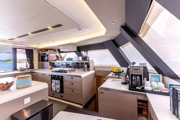 Port To Vino 2 Yacht Photos Pics Luxurious kitchen interior of 2023 Fountaine Pajot Samana 59 yacht with modern appliances.