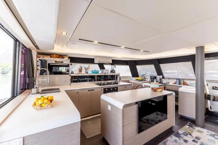Port To Vino 2 Yacht Photos Pics Luxurious interior of 2023 Fountaine Pajot Samana 59 yacht kitchen with modern amenities.