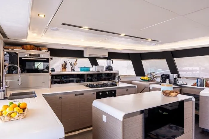 Port To Vino 2 Yacht Photos Pics Luxurious kitchen interior of 2023 Fountaine Pajot Samana 59 yacht with modern amenities.