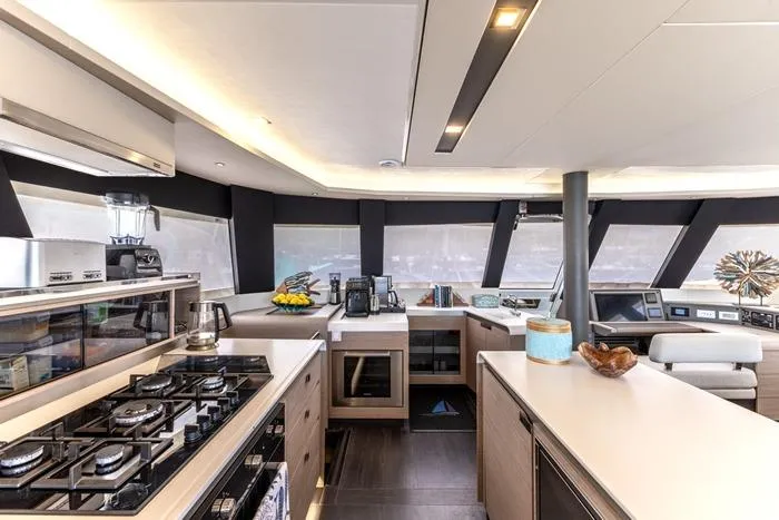 Port To Vino 2 Yacht Photos Pics Luxurious interior of 2023 Fountaine Pajot Samana 59 yacht kitchen with modern appliances.