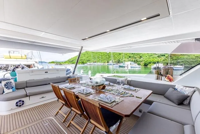 Port To Vino 2 Yacht Photos Pics Luxurious dining area on 2023 Fountaine Pajot Samana 59 yacht, overlooking serene waters.