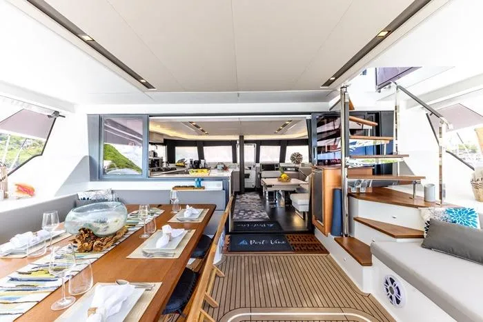 Port To Vino 2 Yacht Photos Pics Luxurious interior of 2023 Fountaine Pajot Samana 59 yacht with elegant dining area.