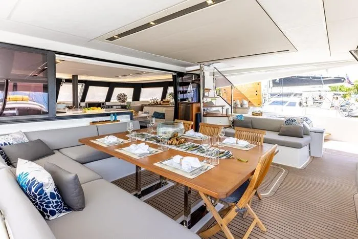 Port To Vino 2 Yacht Photos Pics Luxurious interior of 2023 Fountaine Pajot Samana 59 yacht with elegant dining area.