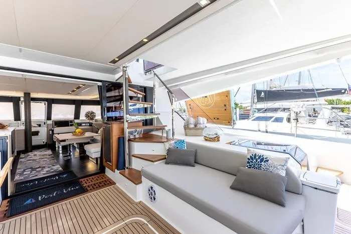 Port To Vino 2 Yacht Photos Pics Luxurious interior of 2023 Fountaine Pajot Samana 59 yacht with modern seating and staircase.