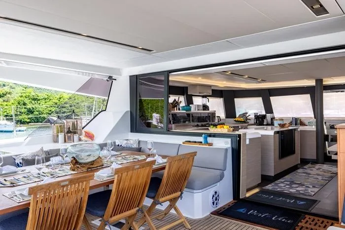 Port To Vino 2 Yacht Photos Pics Luxurious 2023 Fountaine Pajot Samana 59 yacht interior with elegant dining area and modern kitchen.