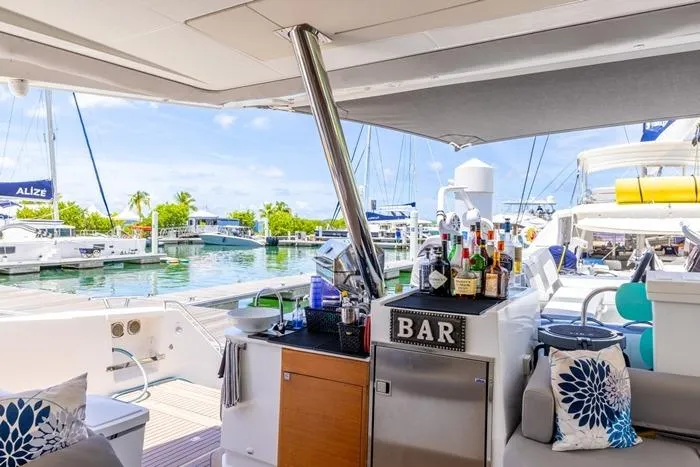 Port To Vino 2 Yacht Photos Pics Luxurious 2023 Fountaine Pajot Samana 59 yacht with outdoor bar and marina view.