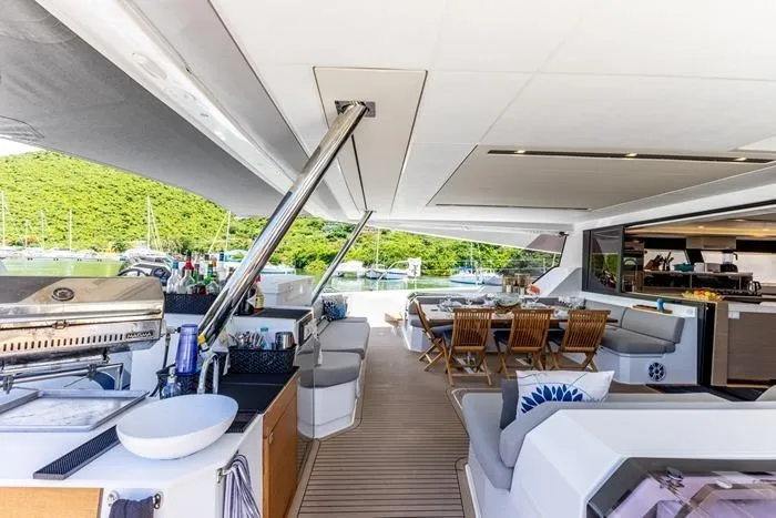 Port To Vino 2 Yacht Photos Pics Luxurious 2023 Fountaine Pajot Samana 59 yacht interior with dining area and outdoor seating.