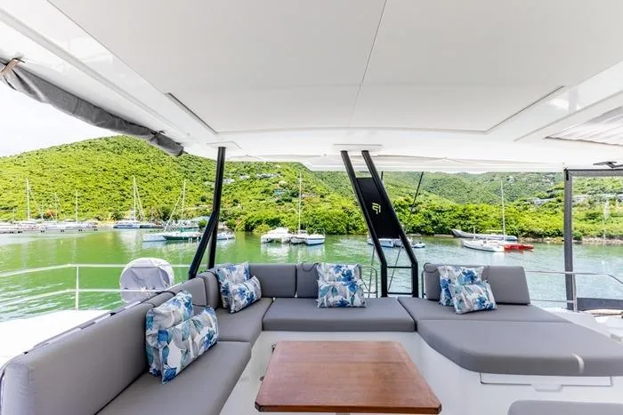 Port To Vino 2 Yacht Photos Pics Luxurious 2023 Fountaine Pajot Samana 59 yacht with spacious outdoor seating and scenic marina view.