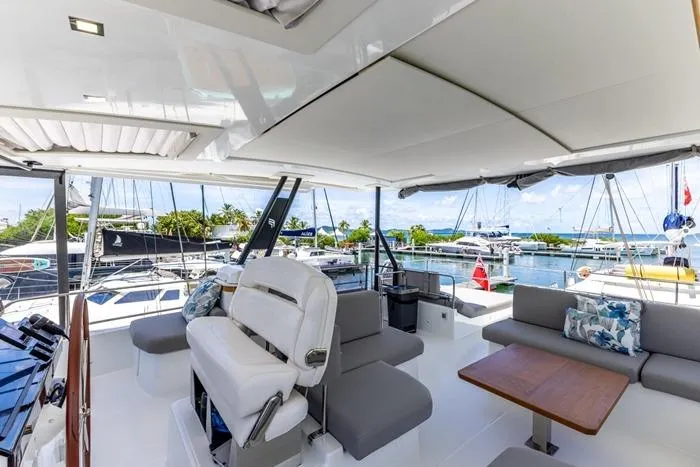Port To Vino 2 Yacht Photos Pics Luxurious 2023 Fountaine Pajot Samana 59 yacht interior with seating and marina view.