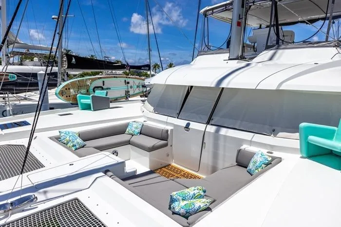 Port To Vino 2 Yacht Photos Pics Luxurious 2023 Fountaine Pajot Samana 59 catamaran with spacious outdoor seating and vibrant cushions.
