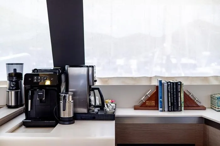 Port To Vino 2 Yacht Photos Pics Coffee station and books on the Fountaine Pajot Samana 59 yacht, 2023 model.