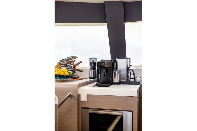 Port To Vino 2 Yacht Photos Pics Modern kitchen area on 2023 Fountaine Pajot Samana 59 yacht with coffee maker and fruit basket.