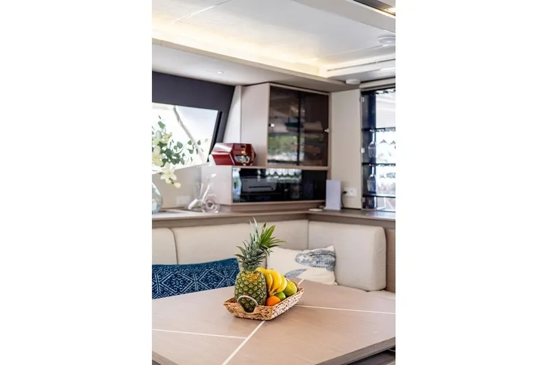Port To Vino 2 Yacht Photos Pics Luxurious interior of 2023 Fountaine Pajot Samana 59 yacht with fruit basket centerpiece.