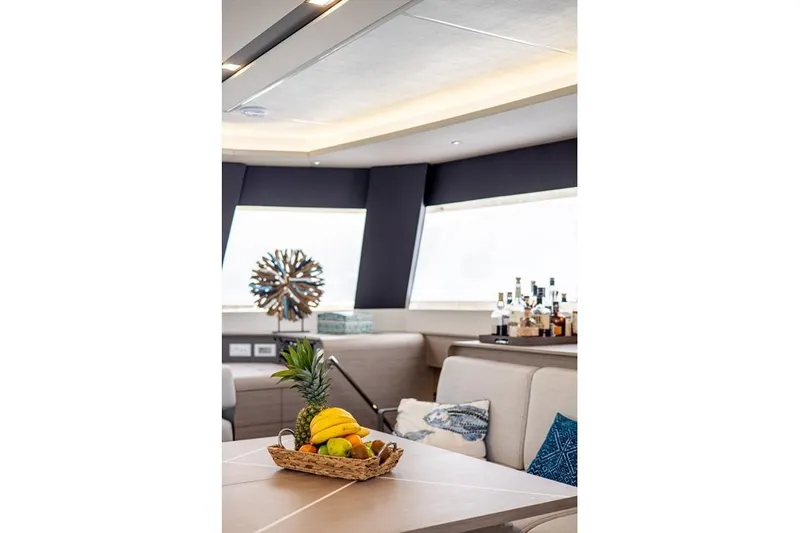 Port To Vino 2 Yacht Photos Pics Luxurious interior of 2023 Fountaine Pajot Samana 59 yacht with fruit basket and bar.