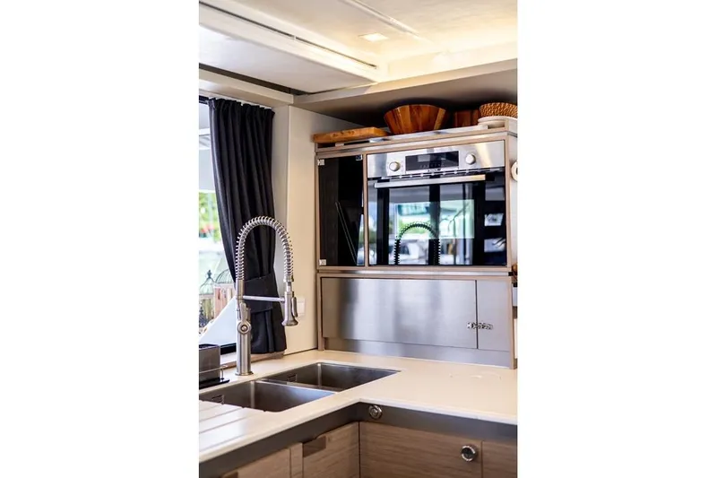 Port To Vino 2 Yacht Photos Pics Modern kitchen interior of 2023 Fountaine Pajot Samana 59 yacht with stainless steel appliances.