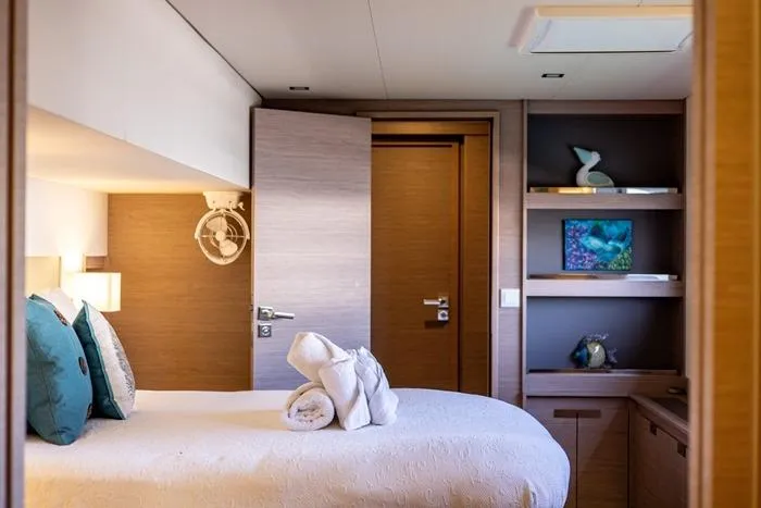 Port To Vino 2 Yacht Photos Pics Luxurious bedroom interior of 2023 Fountaine Pajot Samana 59 yacht with elegant decor.