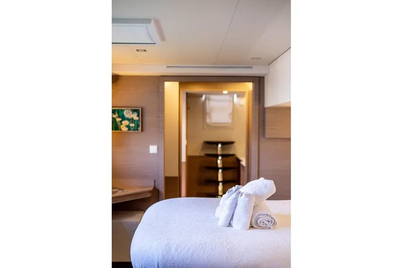 Port To Vino 2 Yacht Photos Pics Luxurious interior of 2023 Fountaine Pajot Samana 59 yacht with elegant decor and plush bedding.