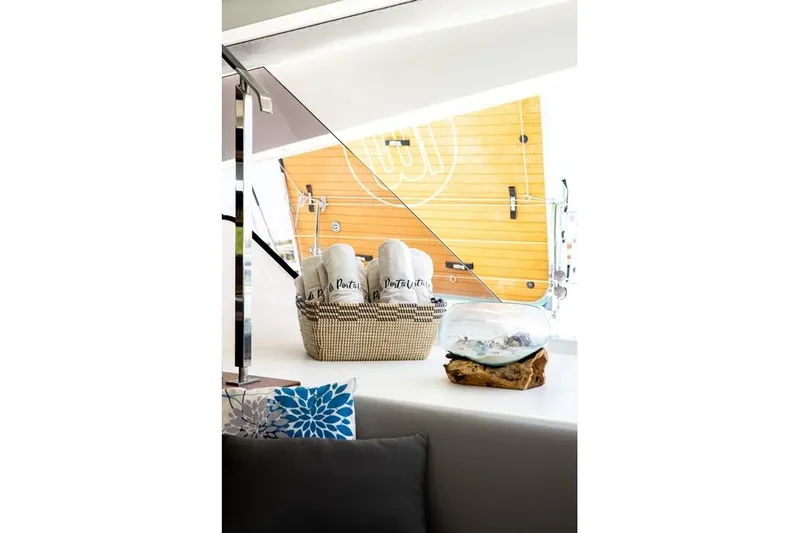 Port To Vino 2 Yacht Photos Pics Interior of 2023 Fountaine Pajot Samana 59 yacht with decorative basket and pillows.