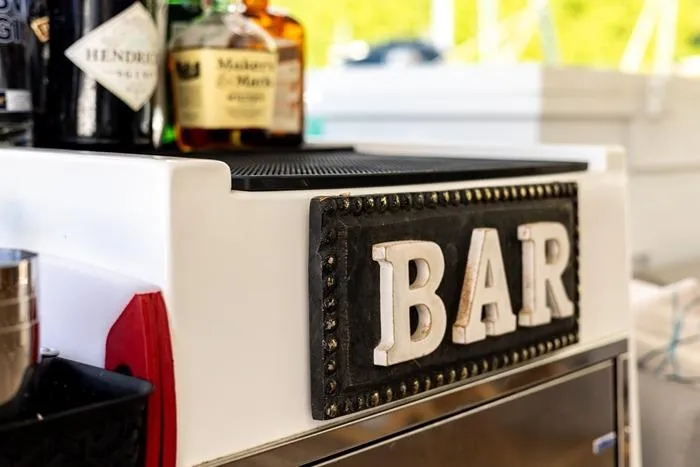 Port To Vino 2 Yacht Photos Pics Bar area on 2023 Fountaine Pajot Samana 59 yacht with liquor bottles displayed.