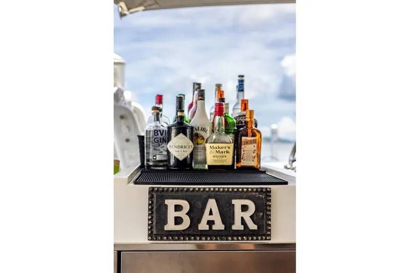 Port To Vino 2 Yacht Photos Pics Bar setup on 2023 Fountaine Pajot Samana 59 yacht with assorted liquor bottles.