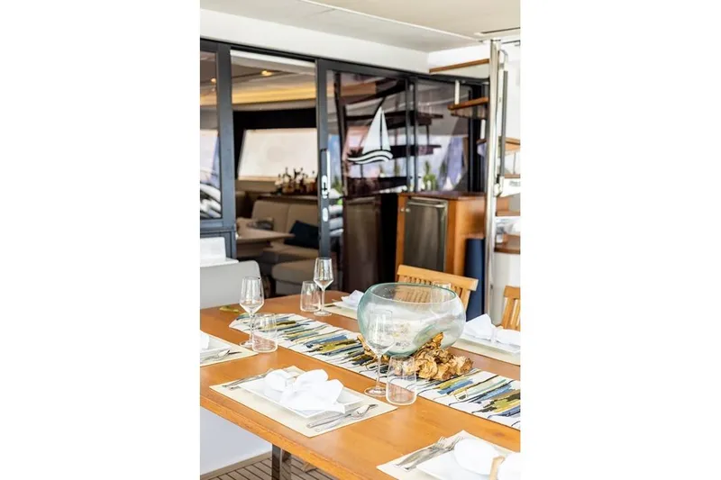 Port To Vino 2 Yacht Photos Pics Elegant dining area on 2023 Fountaine Pajot Samana 59 yacht, featuring stylish table setting.