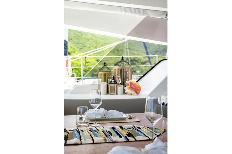 Port To Vino 2 Yacht Photos Pics Elegant dining setup on 2023 Fountaine Pajot Samana 59 yacht, featuring scenic outdoor view.