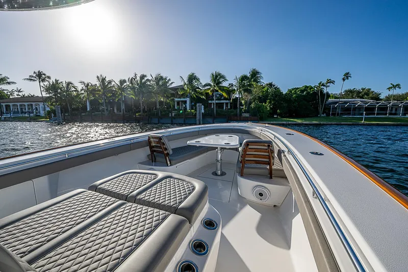 Farniente Yacht Photos Pics 2022 Valhalla Boatworks V41 on water, luxurious seating, sunny day, palm trees in background.
