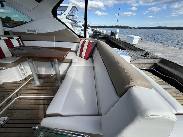  Yacht Photos Pics 2014 Four Winns V435 yacht interior with plush seating and wooden table by the dock.