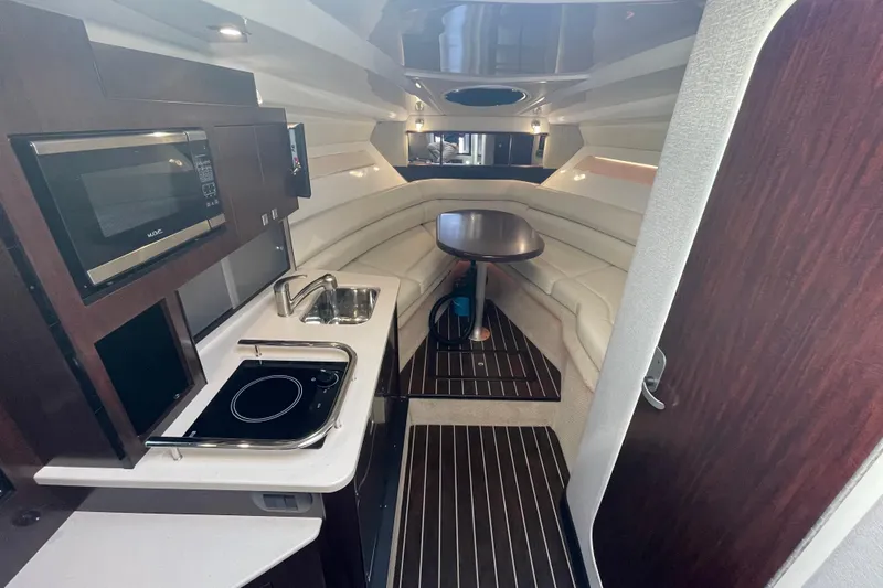  Yacht Photos Pics 2019 Monterey 295 Sport Yacht interior with kitchenette, seating, and dining area.