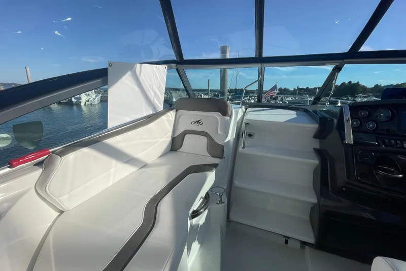  Yacht Photos Pics 2019 Monterey 295 Sport Yacht interior with white seating and dashboard, docked at marina.
