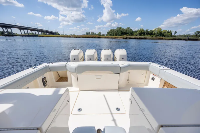  Yacht Photos Pics 2019 Scout 420 LXF boat with spacious deck, four engines, and scenic water view.