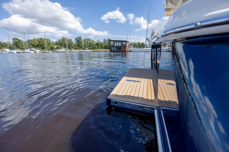  Yacht Photos Pics 2019 Scout 420 LXF yacht with extended deck on calm water, under a blue sky.