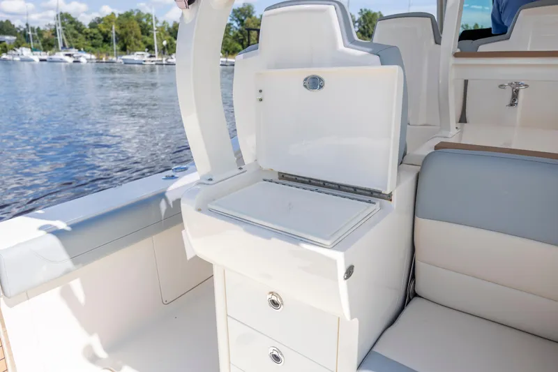 Yacht Photos Pics 2019 Scout 420 LXF boat interior with open storage compartment by the water.
