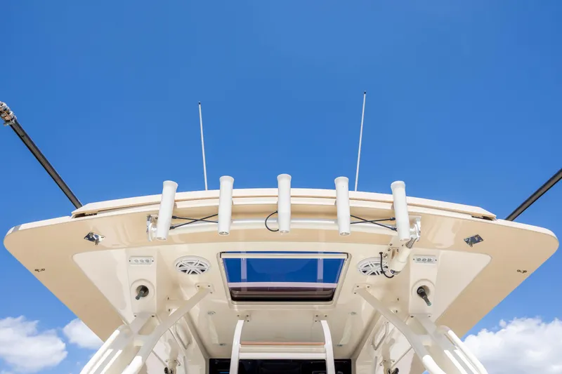  Yacht Photos Pics 2019 Scout 420 LXF boat roof with fishing rod holders against blue sky.